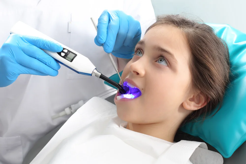 Child Receiving Dental Treatment with Curing Light